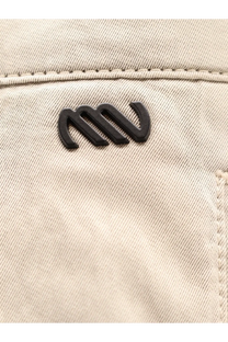 Black plastic logo patch on beige cotton denim fabric of Massimo Osti men’s cotton trousers