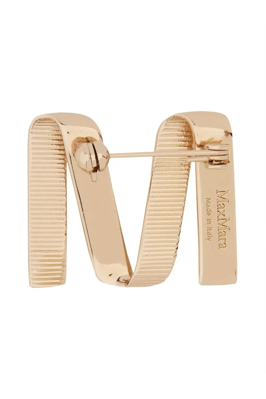 Back side of max mara women’s gold brooch showing gold-tone metal letter m with ribbed texture and engraved branding