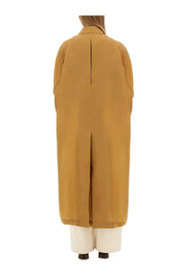 Back view of Max Mara women’s mustard yellow trench coat with central seam and wide sleeves in sack beige style