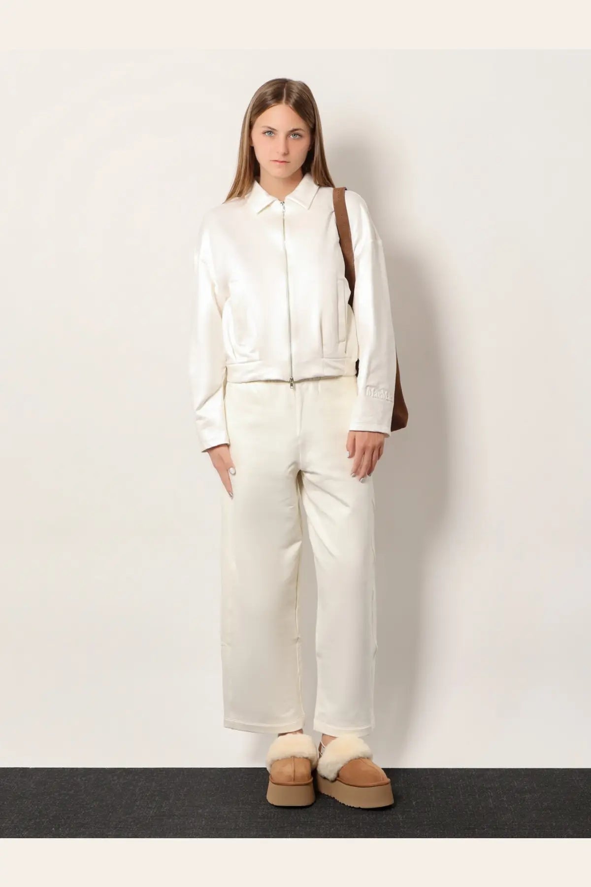 A sleek white leather jacket with front zipper and subtle pleats paired with Max Mara Filovia jogger silk trousers