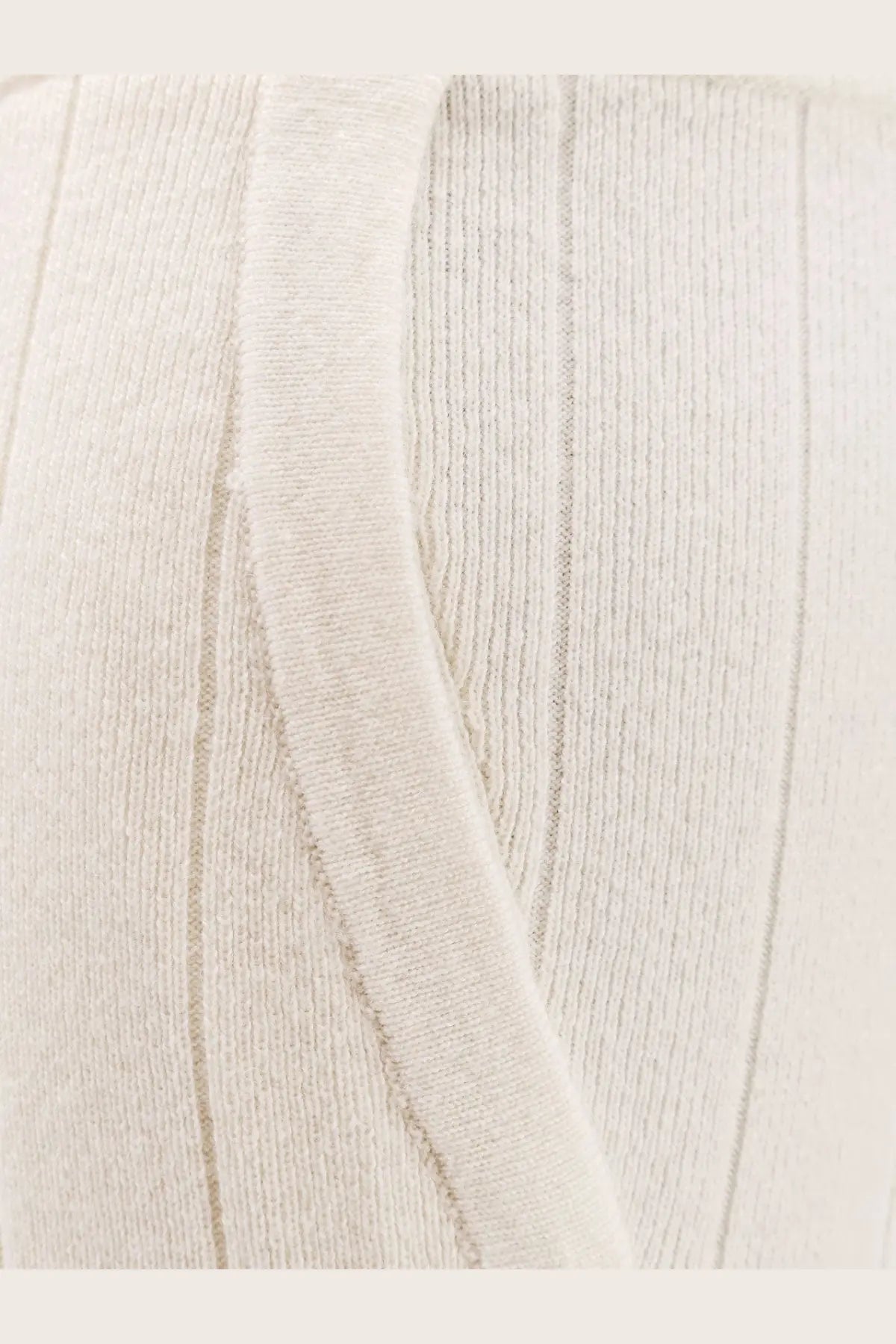 Cream-colored ribbed knit sweater with soft textured fabric and vertical stitching paired with max mara jardin cashmere trousers white