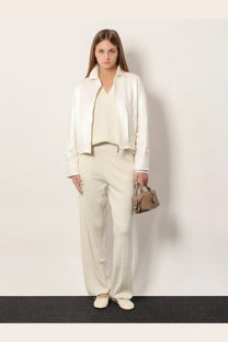 A small structured beige leather handbag with top handle and front flap closure displayed with max mara women’s jardin cashmere trousers white
