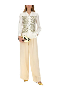 A sleek gold and black panda shaped clutch with a glossy finish paired with max mara women’s klaus beige pants