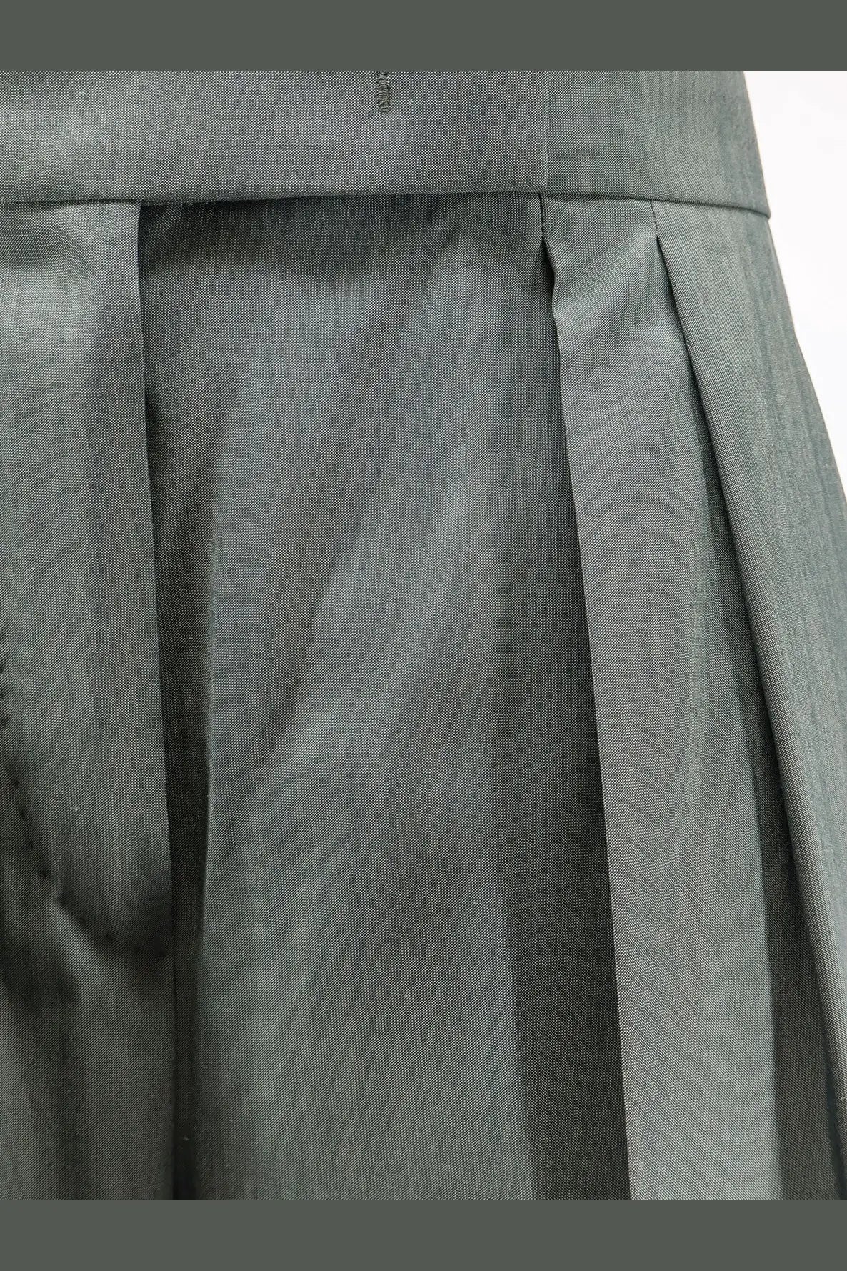 Gray pleated skirt with tailored waistband made of smooth structured fabric paired with max mara green trousers