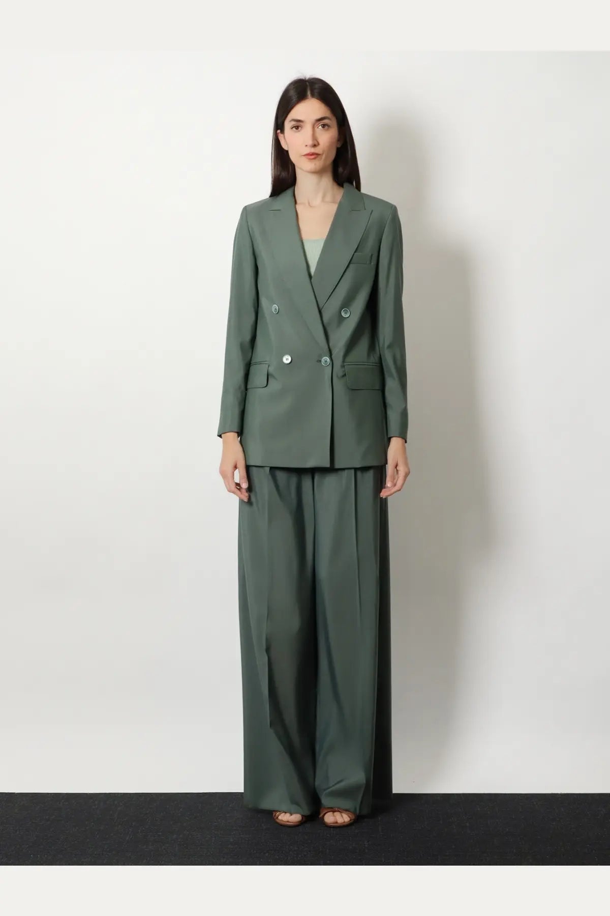A sleek olive green double breasted blazer with silver buttons and structured shoulders paired with max mara trousers