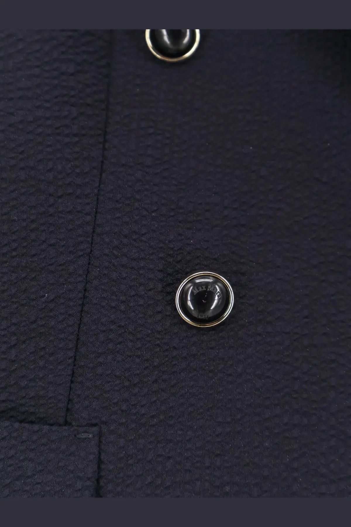 Black circular button with silver metallic rim on textured navy virgin wool fabric of max mara mxmricetta blazer