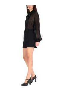 Max Mara women’s Siberia black shorts paired with a black sheer blouse featuring a bow neckline and long sleeves
