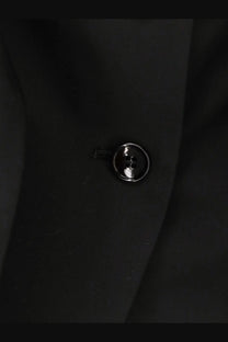 A sleek glossy black button with metallic sheen on max mara women’s veruska virgin wool top black fabric