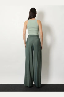 A woman wearing max mara women’s olive green viscose blend tank top paired with wide-leg high-waisted trousers