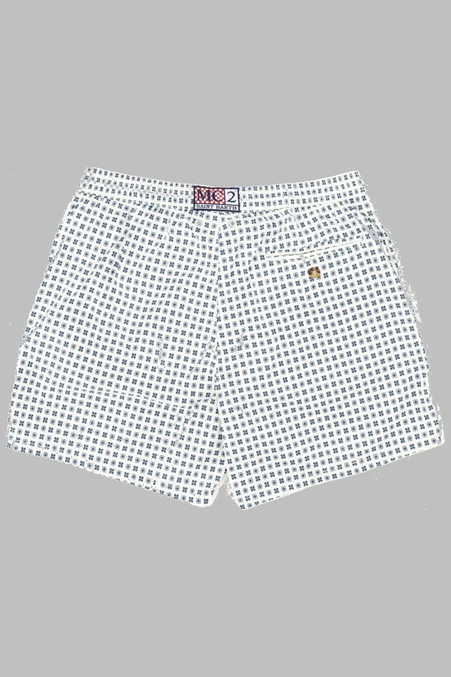 White shorts with a black geometric pattern featuring m2 and ralph lauren logos on the waistband by mc2 saint barth