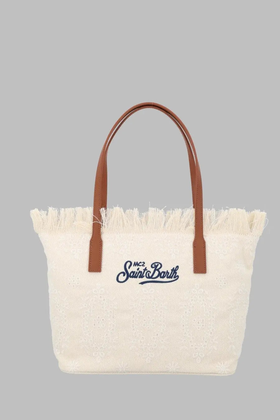 Cream-colored canvas tote bag with brown leather handles and frayed edge featuring embroidered mc2 saint barth logo in navy blue