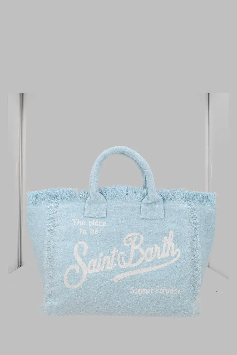 Light blue canvas tote bag with white embroidered saint barth text and frayed edges mc2 saint barth borsa vanity in lino blue