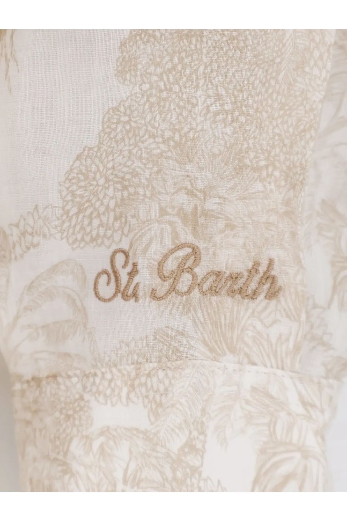 A delicate cream-colored dress with intricate floral pattern and embroidered text st in Mc2 Saint Barth design
