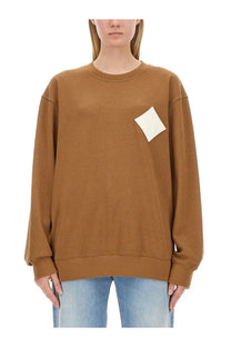 Mcm women’s beige cotton sweatshirt with a tan color and white diamond-shaped patch on the left chest
