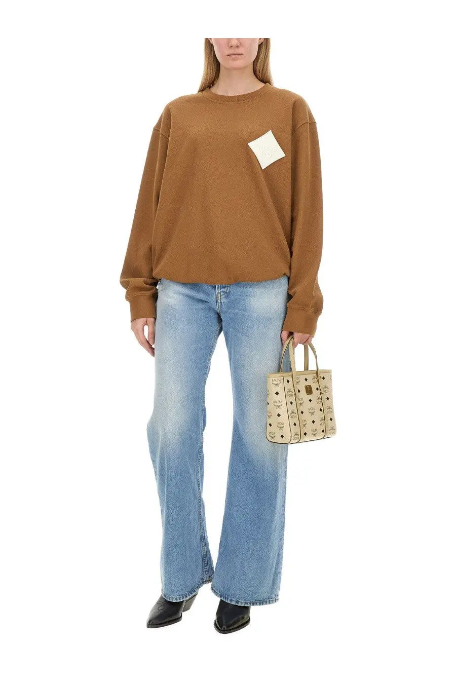 Beige mcm tote bag with signature logo pattern and top handles shown with mcm women’s beige sweatshirt