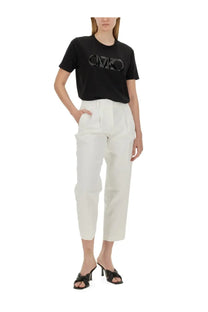 Black short-sleeved t-shirt with reflective ck logo across the chest paired with michael kors women’s white cropped pants
