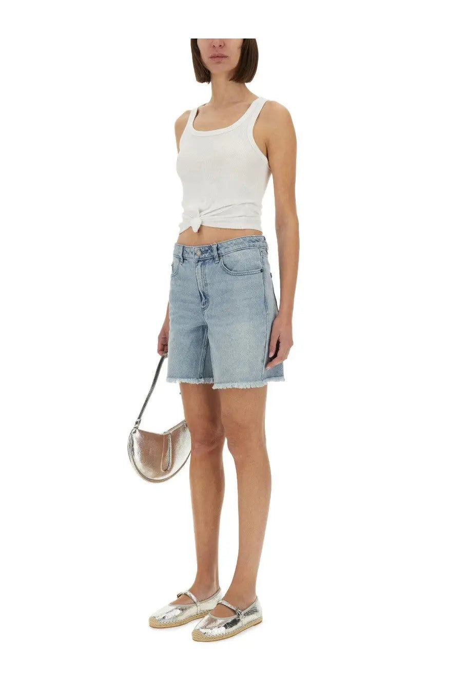 Silver metallic crescent-shaped handbag with slender strap paired with michael kors women’s denim boyfriend shorts blue