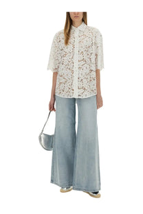 White lace button-up shirt with floral embroidery and short sleeves paired with michael kors women’s blue wide leg jeans