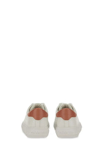 Michael Kors women’s white leather sneaker with a contrasting tan heel tab shown from the back side