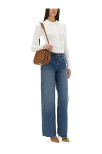 Brown leather saddle bag with single shoulder strap and rounded top handle paired with michael kors women’s white ribbed cardigan