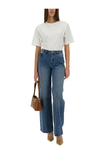 A tan leather handbag with a structured minimalist design and gold-tone hardware paired with michael kors womens straight leg blue jeans