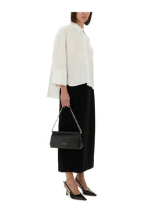 Black leather michael kors crossbody bag with silver chain strap shown with textured crepe maxi skirt black