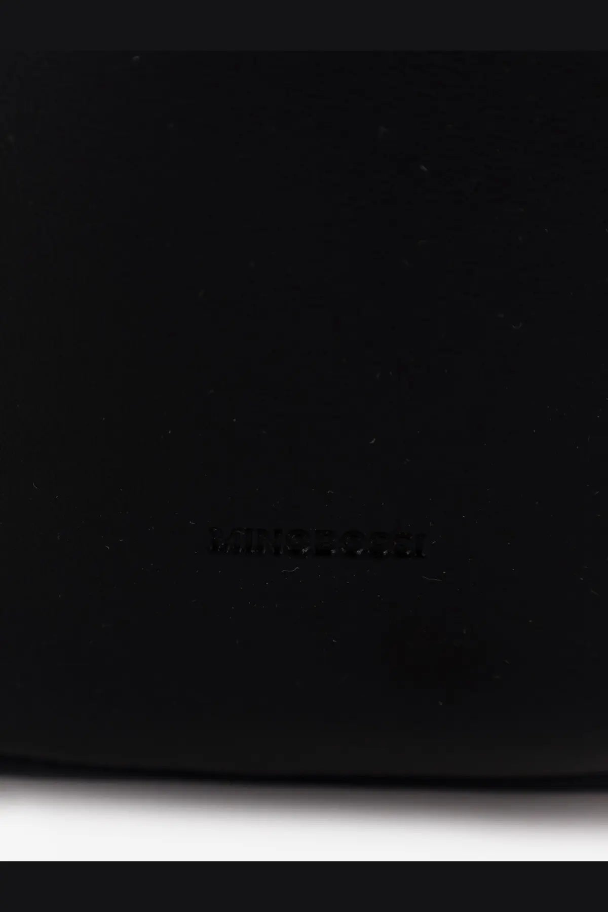 Minobossi women’s liz leather crossbody bag black with embossed brand logo on black leather surface