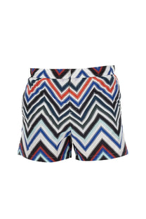 Missoni men’s swimsuit featuring vibrant multicolor zigzag-patterned swim shorts in bold red blue black and white stripes