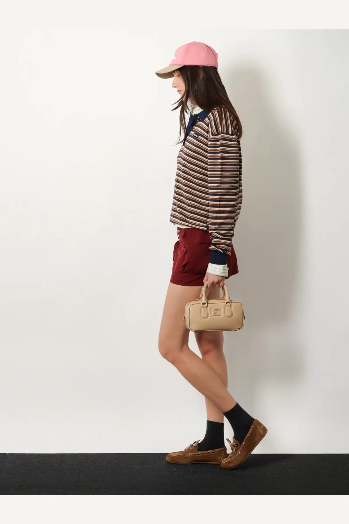 Beige leather mini handbag with top handle and front flap closure paired with miu miu women’s red cotton mini skirt