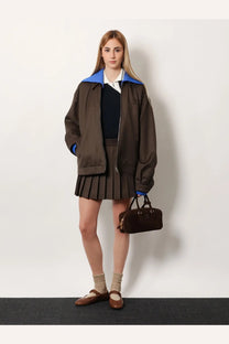 Brown suede handbag with black leather handles and small metallic logo paired with miu miu women’s blue cotton polo shirt