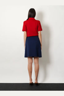 Miu Miu women’s skirt baltico in navy blue paired with a red short-sleeved polo shirt with collar