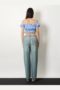 Light-wash denim jeans with relaxed wide-leg cut and subtle distressing paired with miu miu women’s blue striped cotton top