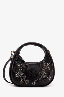Black miu miu leather handbag with shiny crystal embellishments and a curved top handle for elegant wear