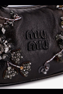 Black leather miu miu women’s wander mini crossbody bag with intricate silver and clear crystal embellishments