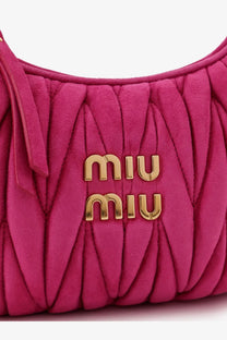 A vibrant fuchsia Miu Miu women’s Wander Matelassé suede shoulder bag with quilted texture and gold-tone logo hardware