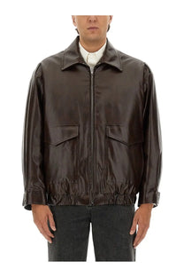 A sleek dark brown faux leather bomber jacket with matte finish and two front flap pockets from MM6 Maison Margiela