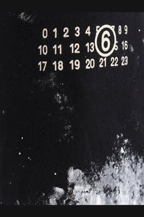 Black cotton jogging trousers for women by mm6 maison margiela with a black fabric calendar featuring white numbers and a circled 6