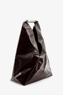 A sleek black patent leather tote bag with minimalist silver metal handle for stylish shoulder wear