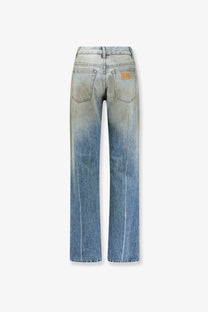 Back view of mm6 maison margiela women’s high-waisted denim jeans in blue with gradient fade and leather patch on pocket