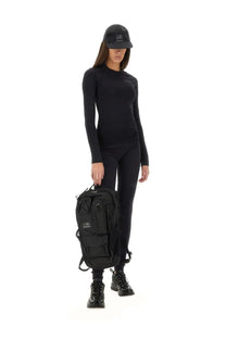 Black tactical backpack with multiple compartments and minimalist logo patch paired with mm6 maison margiela women’s black leggings