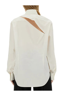 Back view of mm6 maison margiela women’s cream long-sleeved oversize fit blouse with diagonal cutout revealing tan fabric