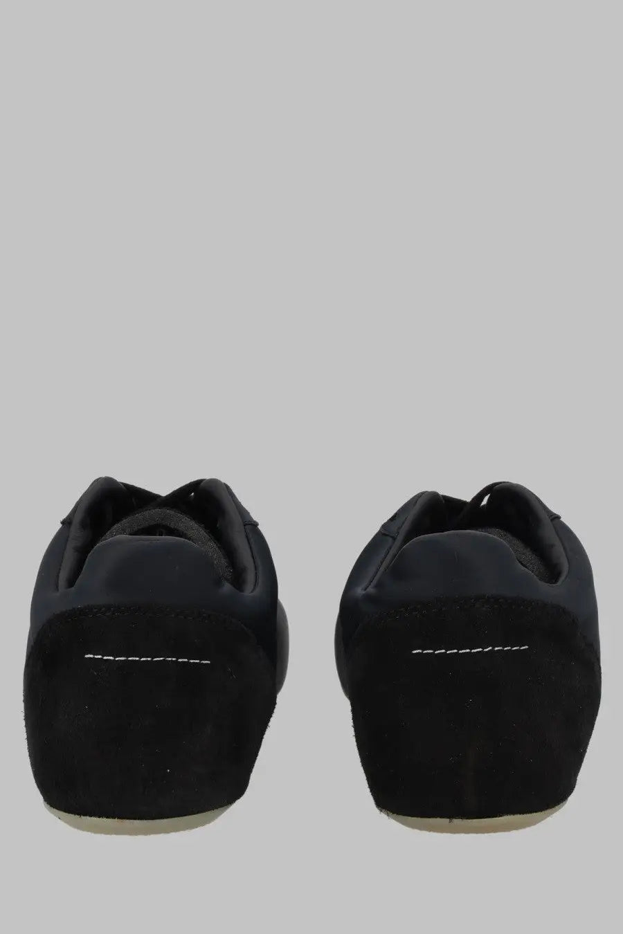 Back view of mm6 maison margiela women’s raso black sneaker showing black suede with white stitching on heel