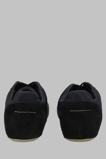Back view of mm6 maison margiela women’s raso black sneaker showing black suede with white stitching on heel