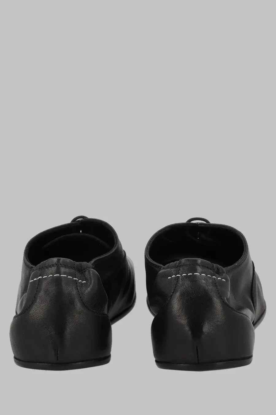 Back view of mm6 maison margiela womens stringata black leather dress shoes with white stitching along the back