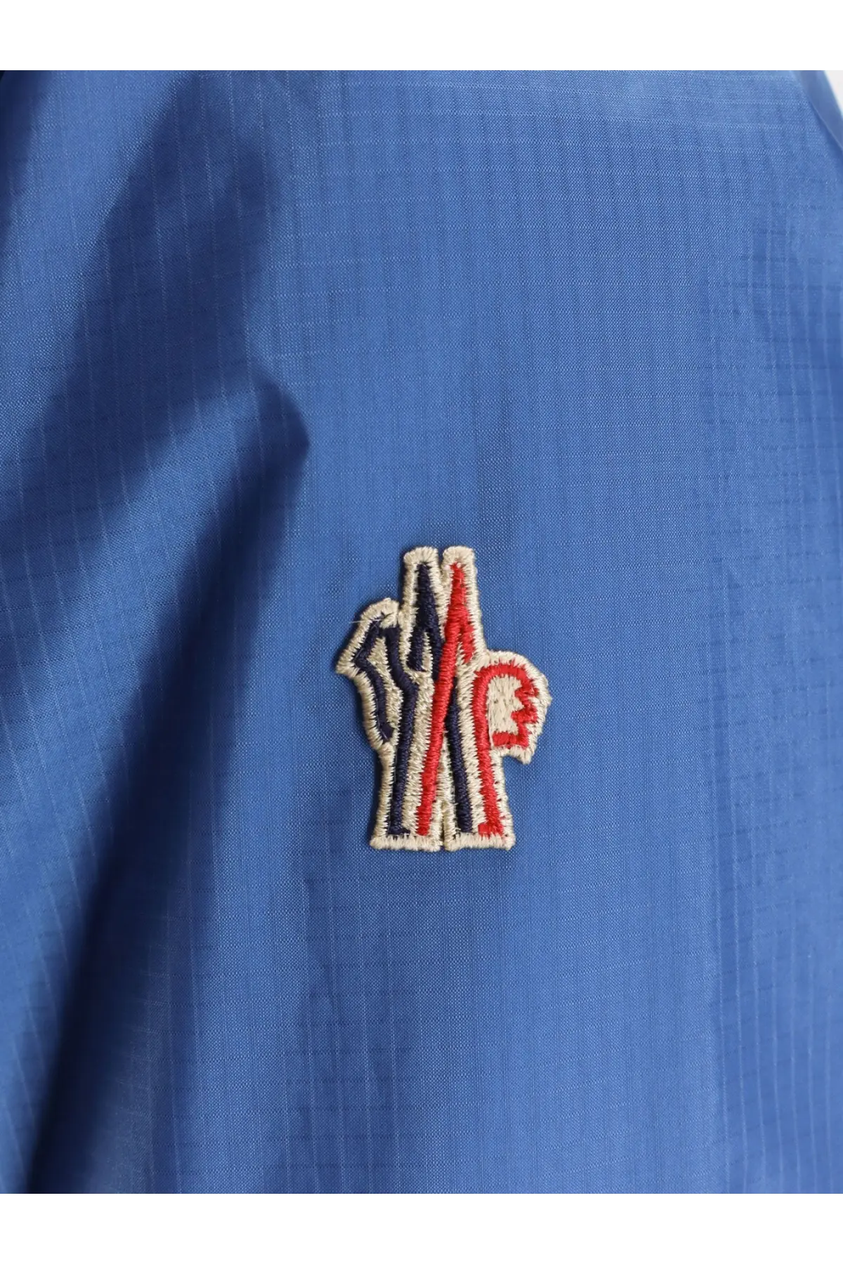 Blue Moncler Grenoble men’s Thurn windstopper jacket with embroidered red white and navy logo on the back
