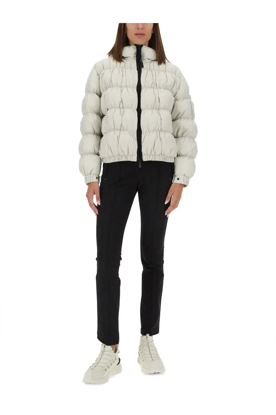 A puffy off-white quilted down jacket with high collar and black zipper paired with moncler grenoble women’s black pants