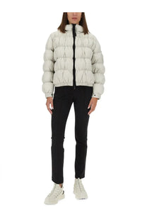 A puffy off-white quilted down jacket with high collar and black zipper paired with moncler grenoble women’s black pants