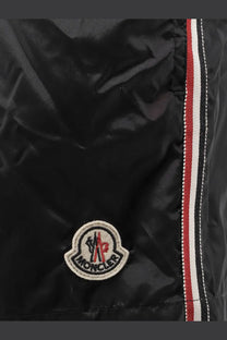 Black moncler men’s nylon puffer jacket with circular embroidered logo and red white black striped zipper tape