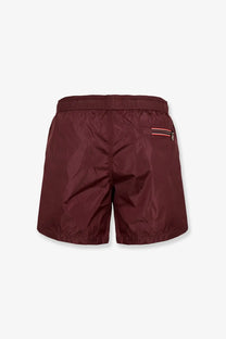 Moncler men’s brown nylon swim trunks with subtle sheen and side pocket with red white and black striped zipper trim
