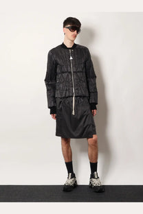 Black quilted bomber jacket with white zipper and triangular logo at collar from moncler and rick owens